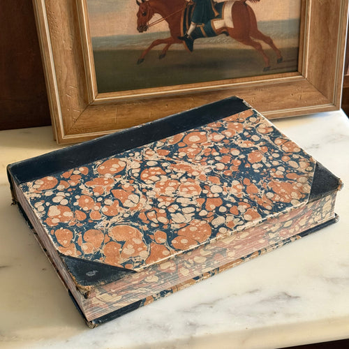 Side view of a 1928 Danish animal encyclopedia showing colorful marbled book edges.