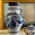 Antique 10-inch German Westerwald salt-glazed stoneware pitcher with cobalt blue floral designs.