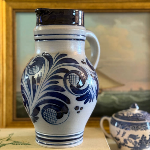 Antique 10-inch German Westerwald salt-glazed stoneware pitcher with cobalt blue floral designs.