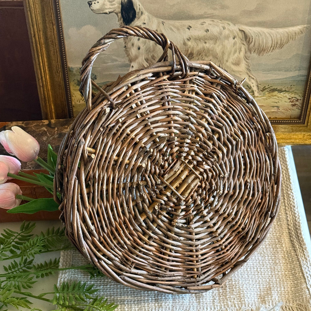 Woven basket on a surface with decorative elements in the background