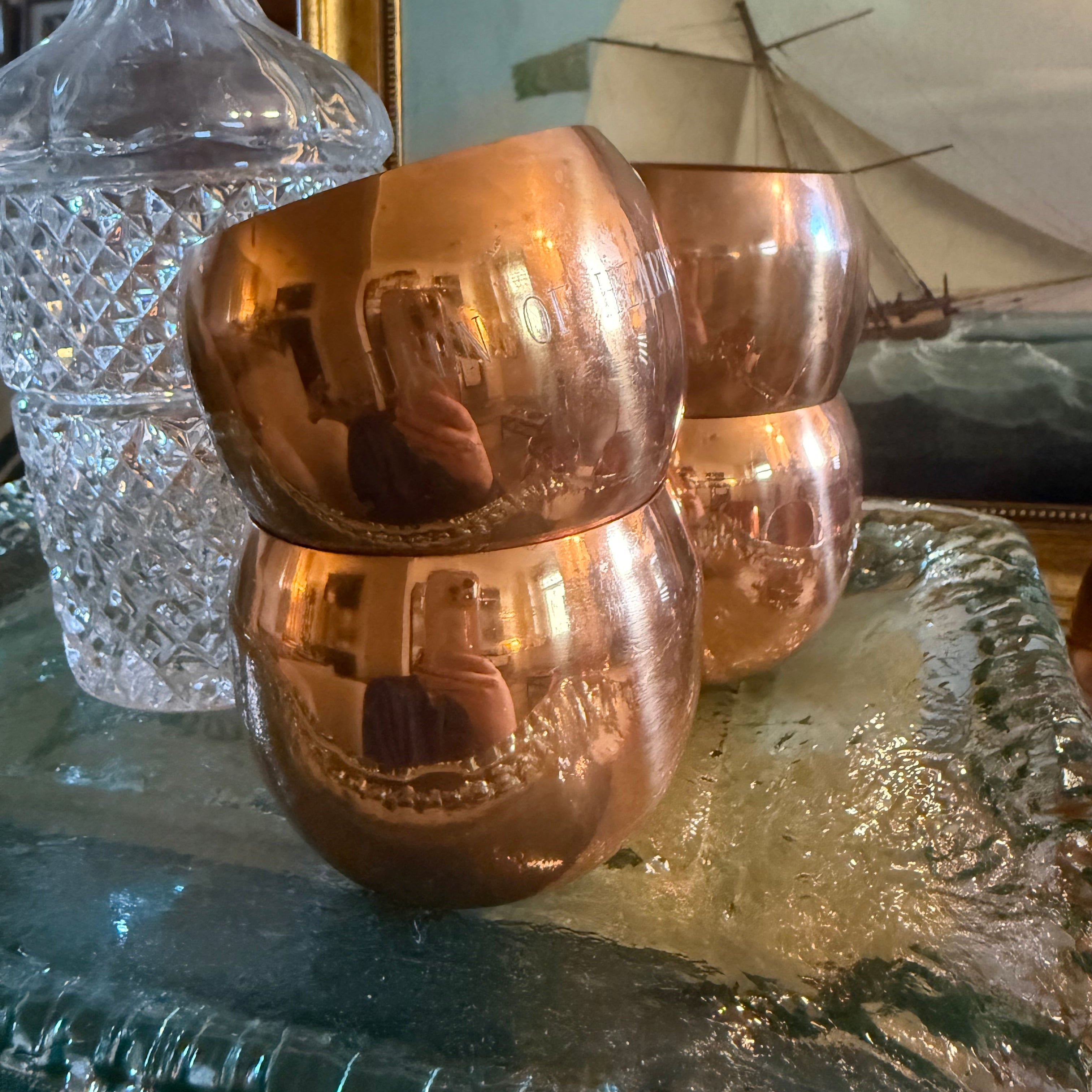 Set of copper wine glasses on a decorative surface with a blurred background