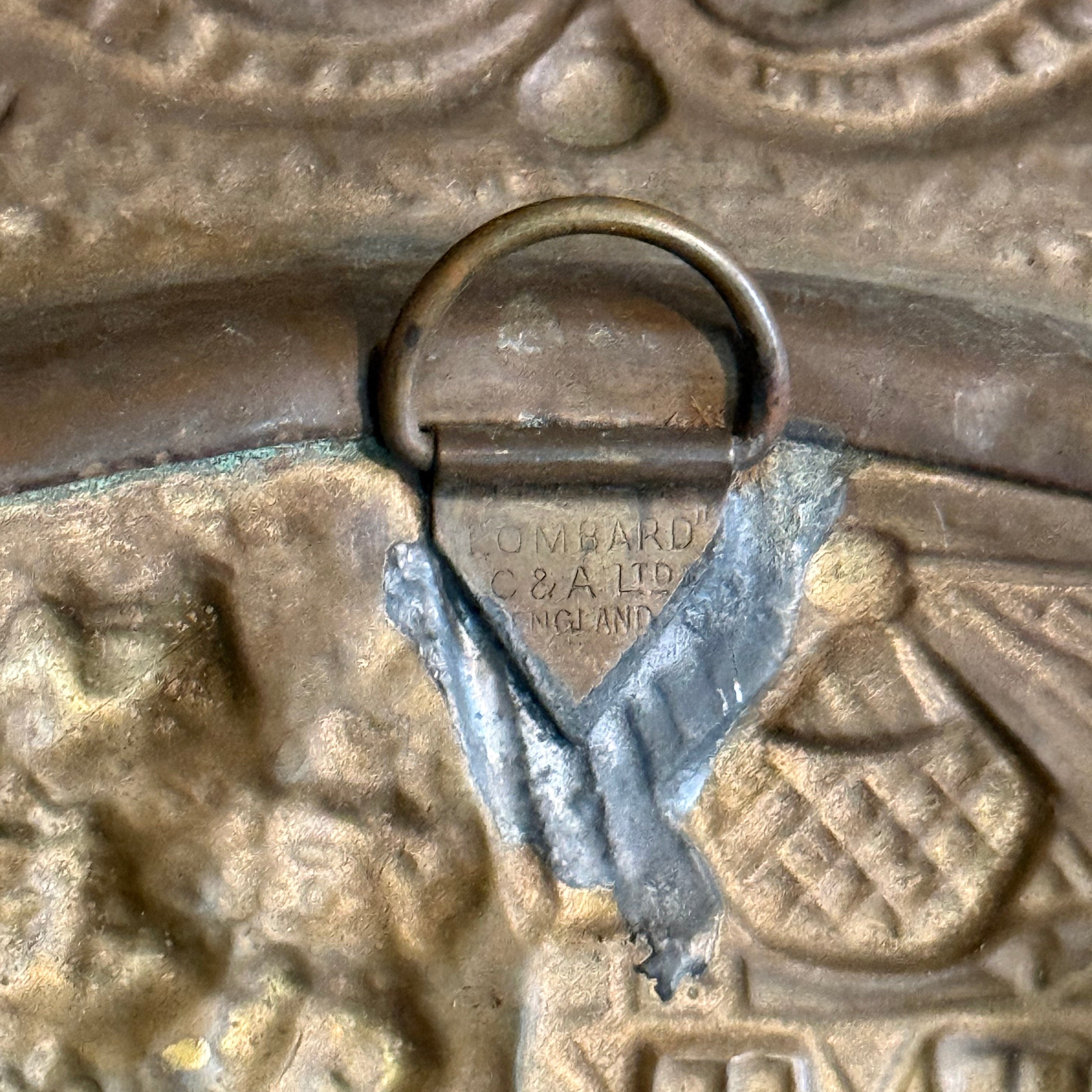 Close up of the intricate brass embossing showing figures in a traditional tavern