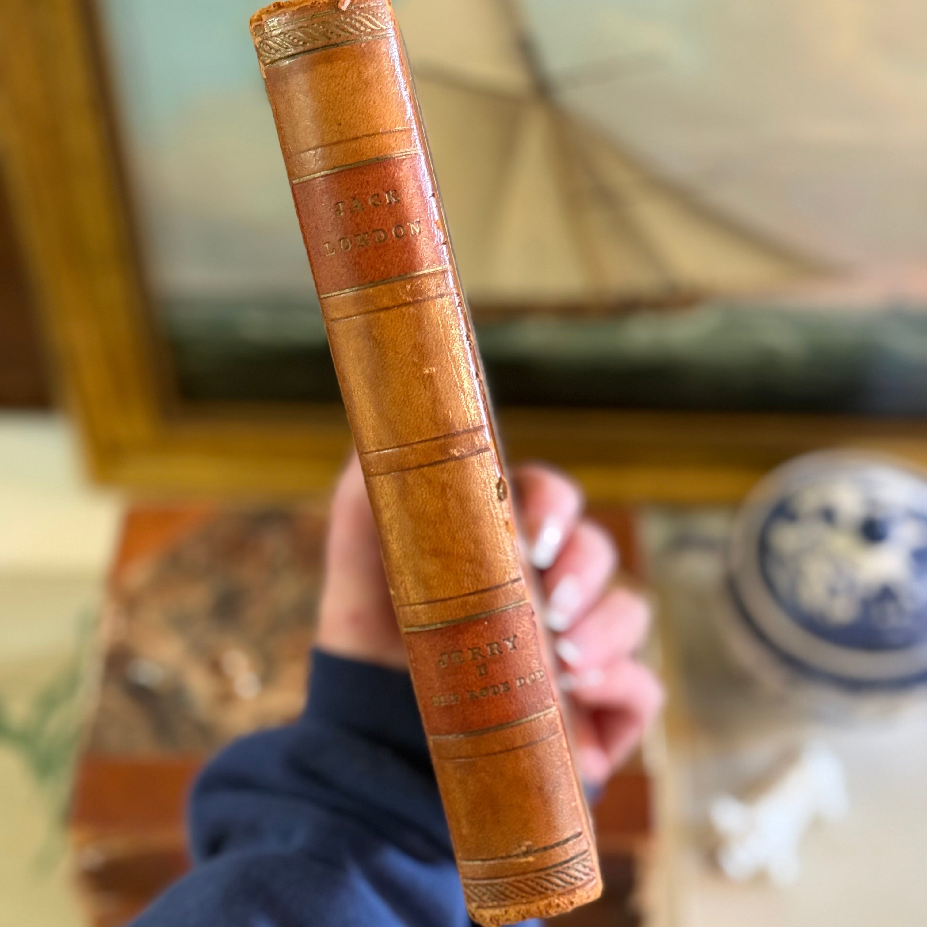A hand holding one of the Danish Jack London books to show size and scale.
