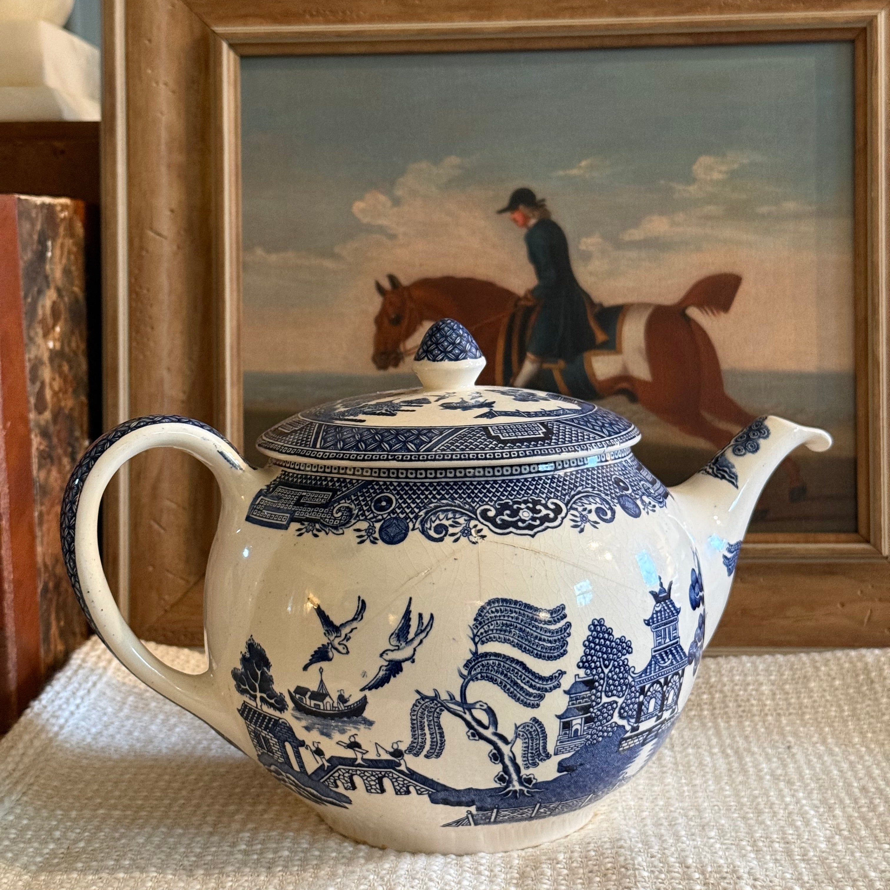 Classic Johnson Bros Blue Willow blue and white ironstone teapot on a white linen cloth