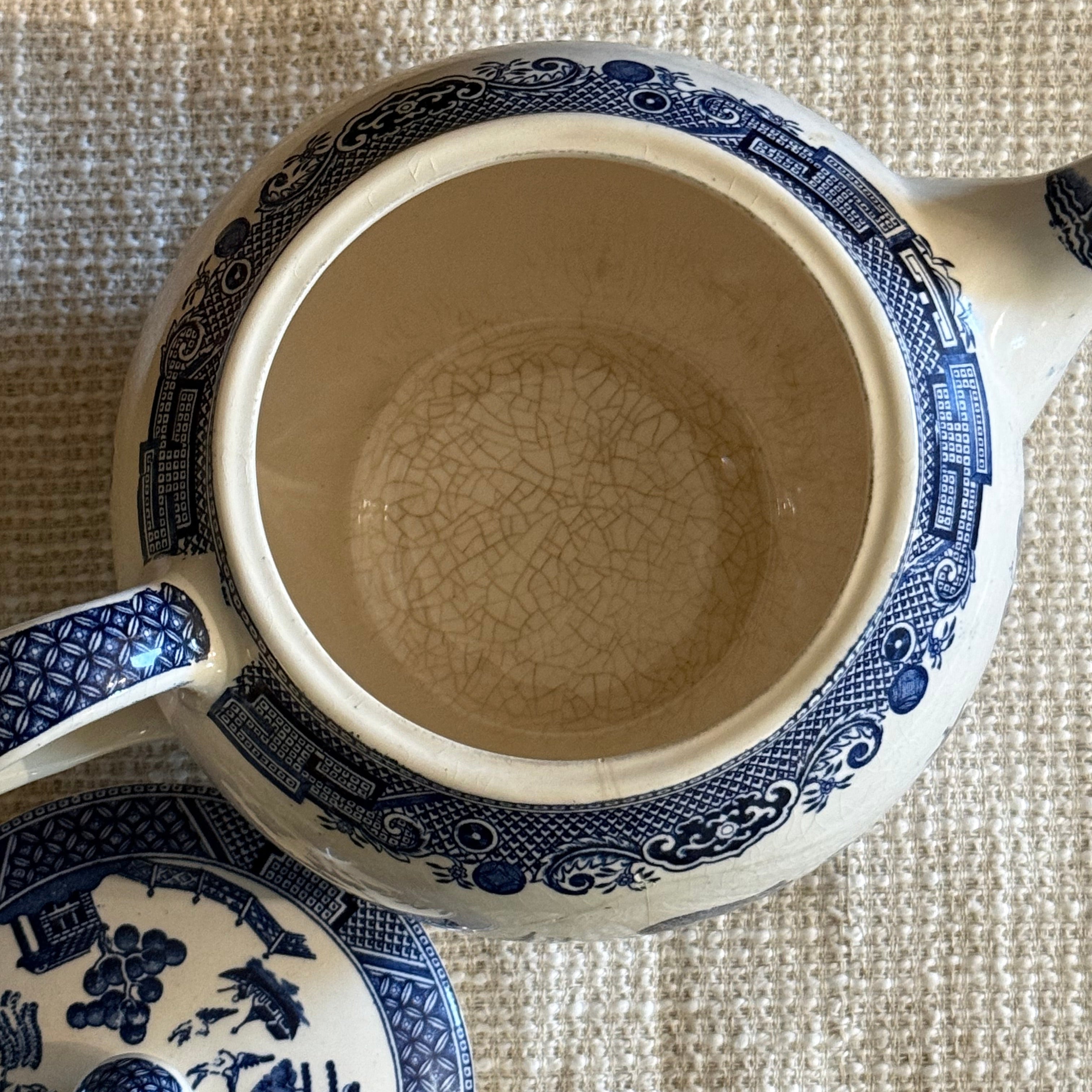 Detail view of the cobalt blue transferware pattern on a vintage English teapot.