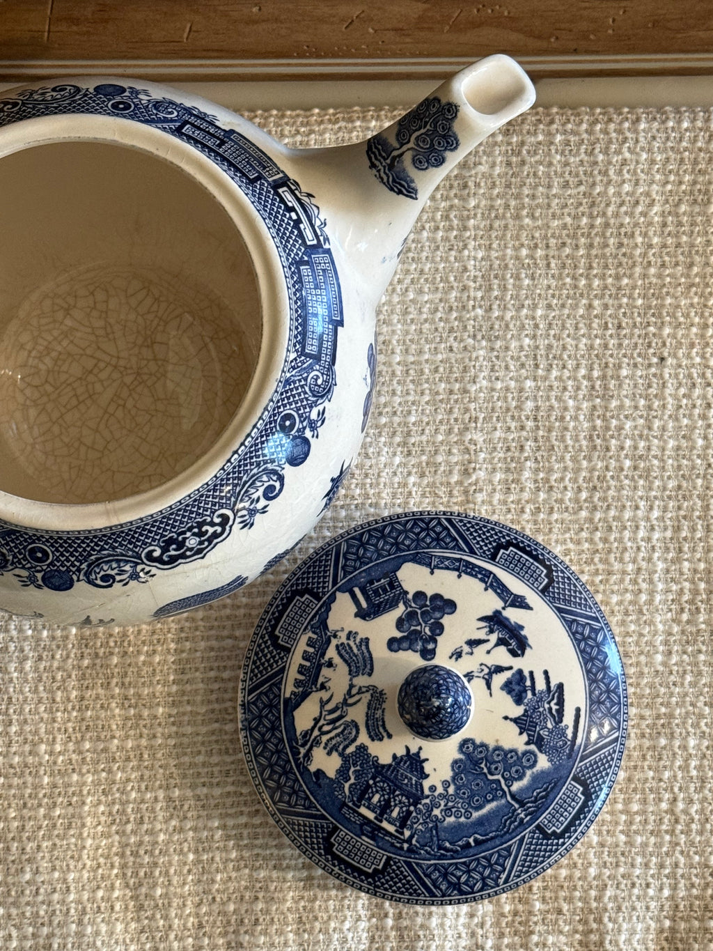 Blue and white English teapot with lid on a linen surface