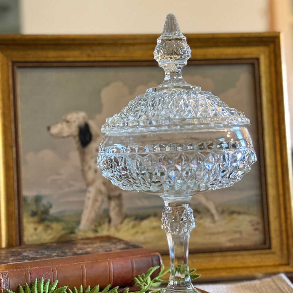 Crystal Indiana glass vintage dish on a wooden stand with a framed painting of a dog in the background
