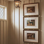 Video showing a stacked gallery wall featuring three ornate gold framed vintage racehorse prints in a sunlit entryway