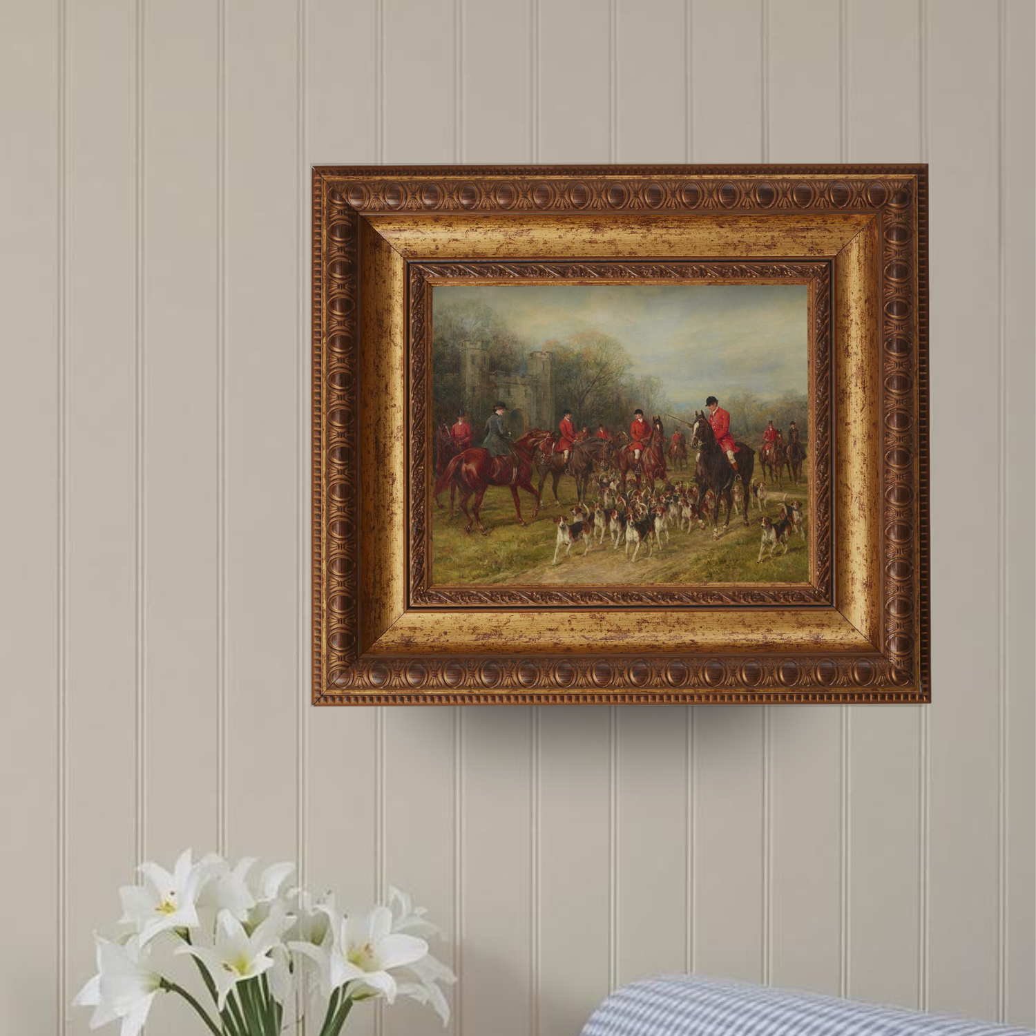 Traditional English hunting art in a gold frame styled above a gingham couch on neutral gallery wall