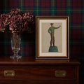 Framed Frank Gray jockey hitching post art print styled on a dark wood chest against a green tartan plaid wall with dried burgundy flowers in a crystal vase.