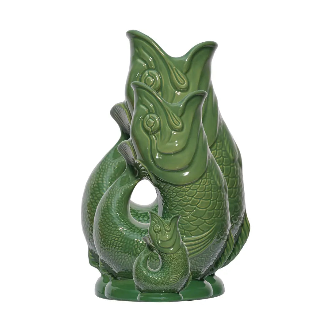 Three classic green ceramic fish-shaped Gluggle Jugs arranged by size—Mini, Large, and Extra-Large—showcasing the iconic British design.
