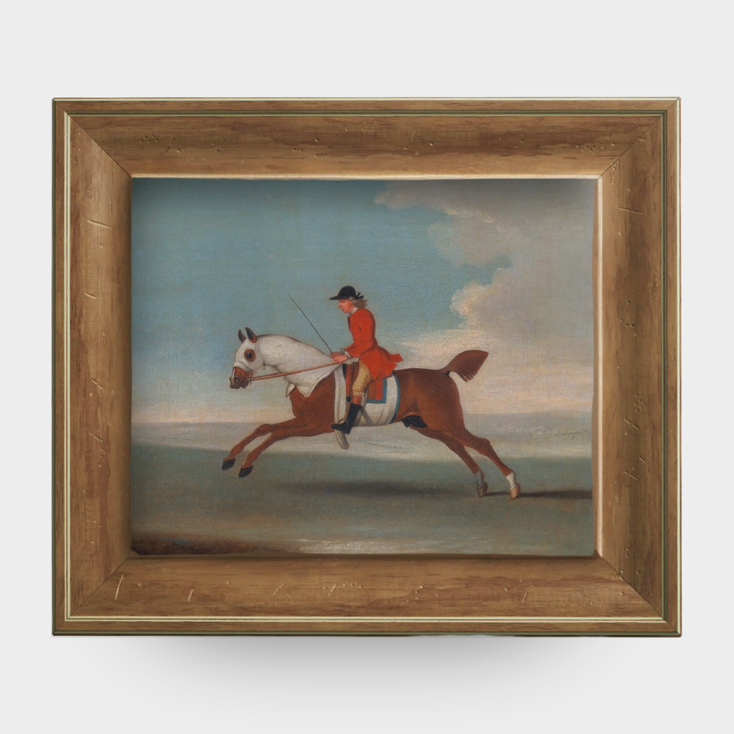 A chestnut racehorse art print in a natural English pine frame isolated on a white background.