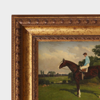 Framed painting of a jockey on a horse in a pastoral setting