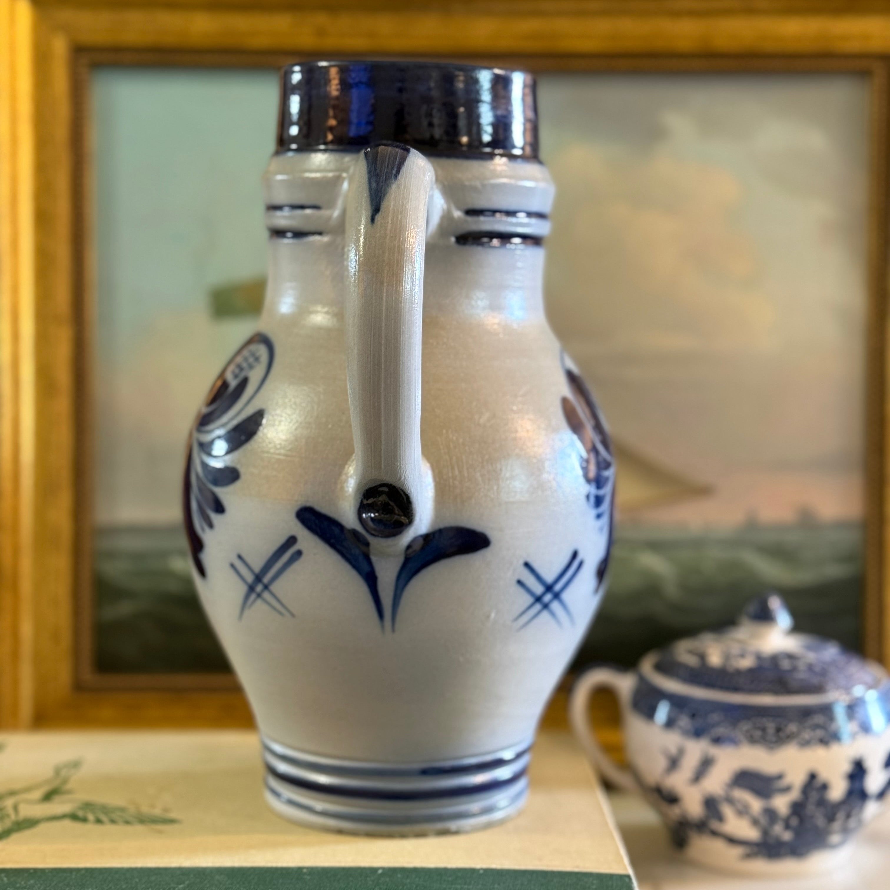 Side profile of a vintage German stoneware pitcher showing the handle and orange-peel texture.