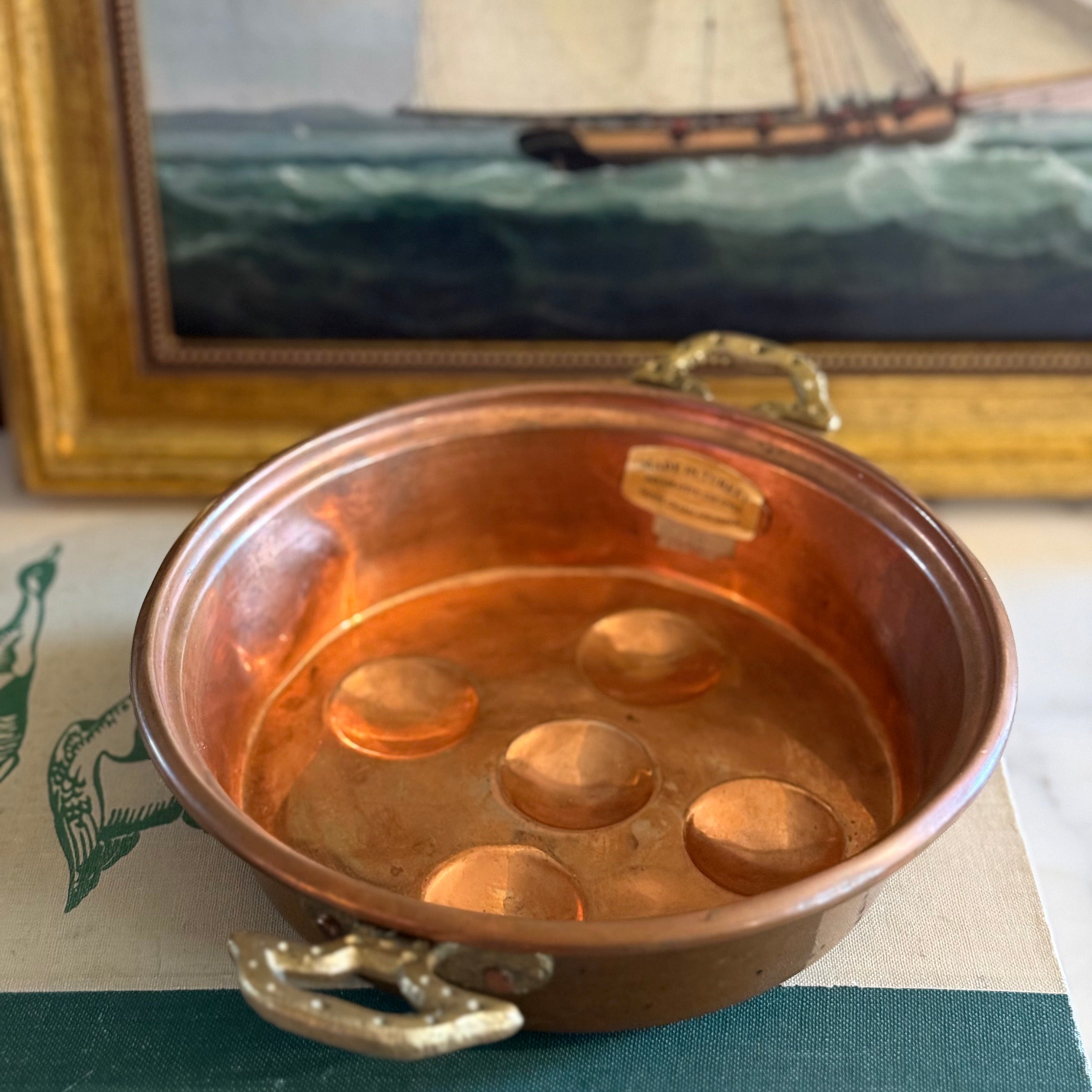 Hand-hammered vintage copper egg poacher with five wells and ornate brass handles