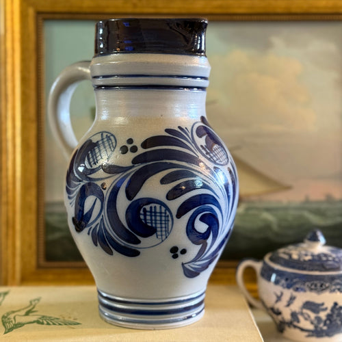 Close up of the hand-painted blue flowers on a grey salt-glazed Bembel pitcher